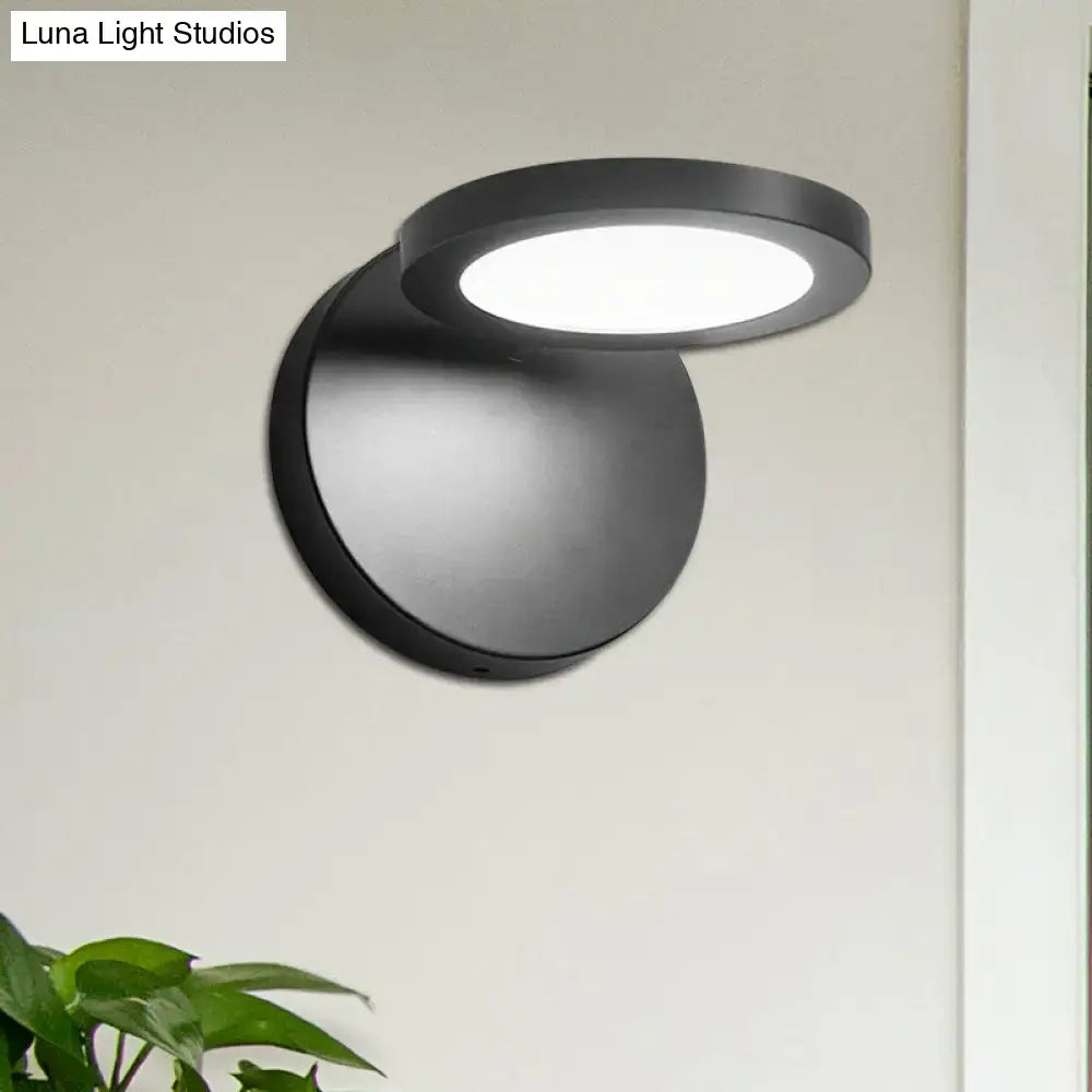 Modern black circular wall lamp with frosted glass diffuser providing white warm lighting for bedroom use