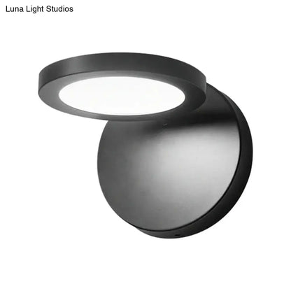 Modern black circular wall lamp with frosted glass diffuser providing white warm lighting for bedroom use