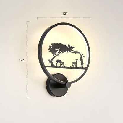 Modern black circular led wall sconce light fixture with deer and tree silhouette design, warm glowing backlight, 12 inches high