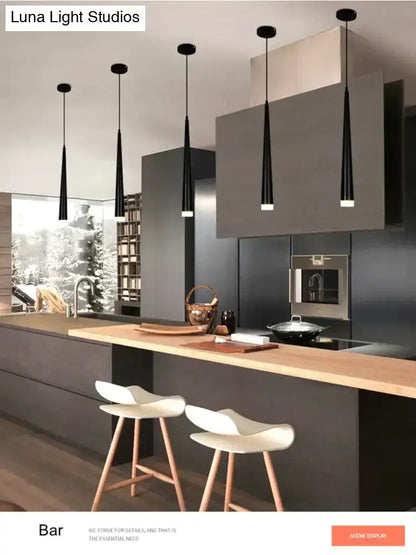 Five sleek black modern conical led pendant lamps with tapered shades hang above a kitchen island