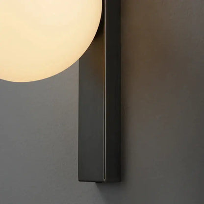 Modern black copper globe led wall sconce with matte black finish and warm frosted glass globe for bedroom lighting