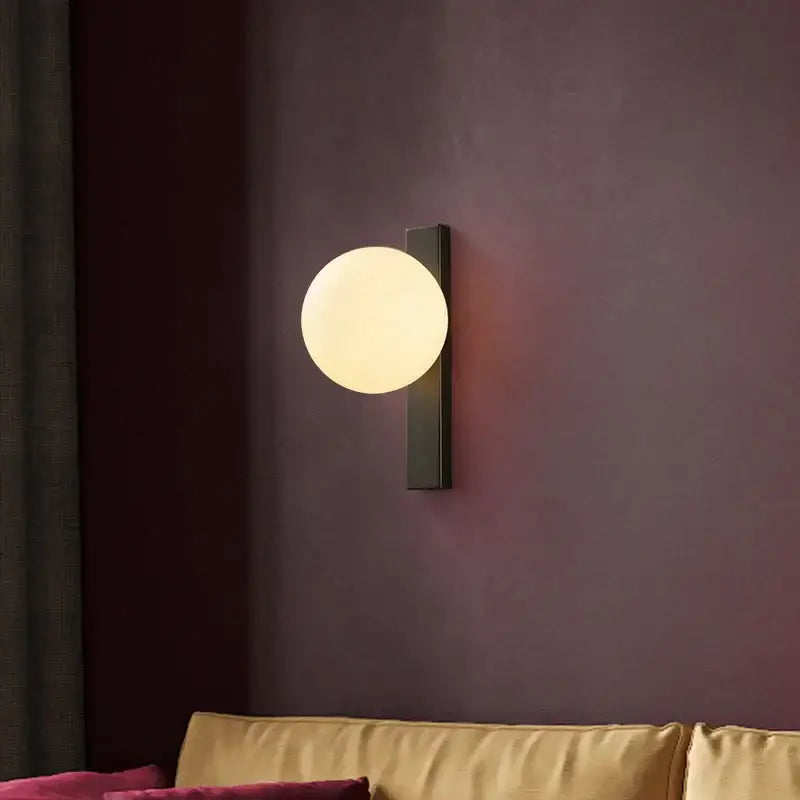 Modern black copper led wall sconce with a matte black rectangular base and frosted white glass globe for bedroom use