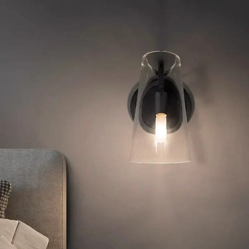Modern wall lamp with black copper base and glass pendant featuring an exposed bulb decorbites black copper design