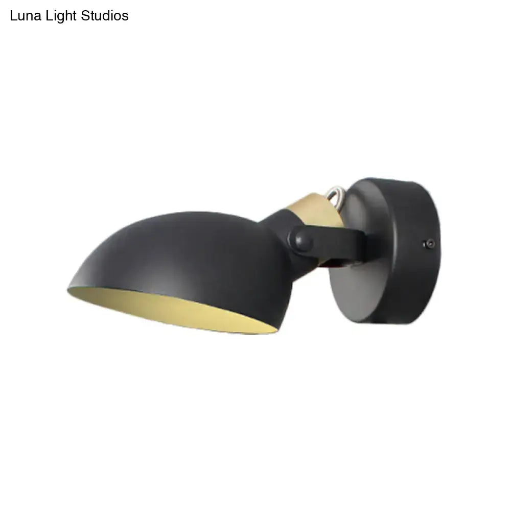 Modern black and cream wall sconce light with matte finish gold interior and adjustable arm for bedroom lighting