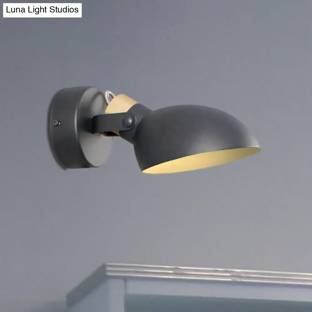 Modern black and cream wall sconce light with matte finish, warm yellow interior, and adjustable arm for bedroom use