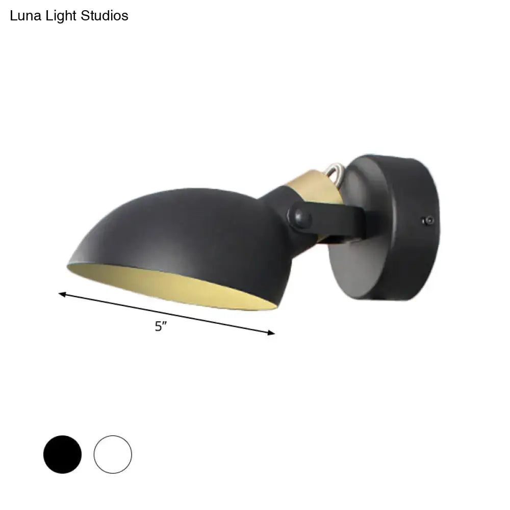 Modern style wall sconce light in black matte finish with gold interior and adjustable arm for bedroom illumination