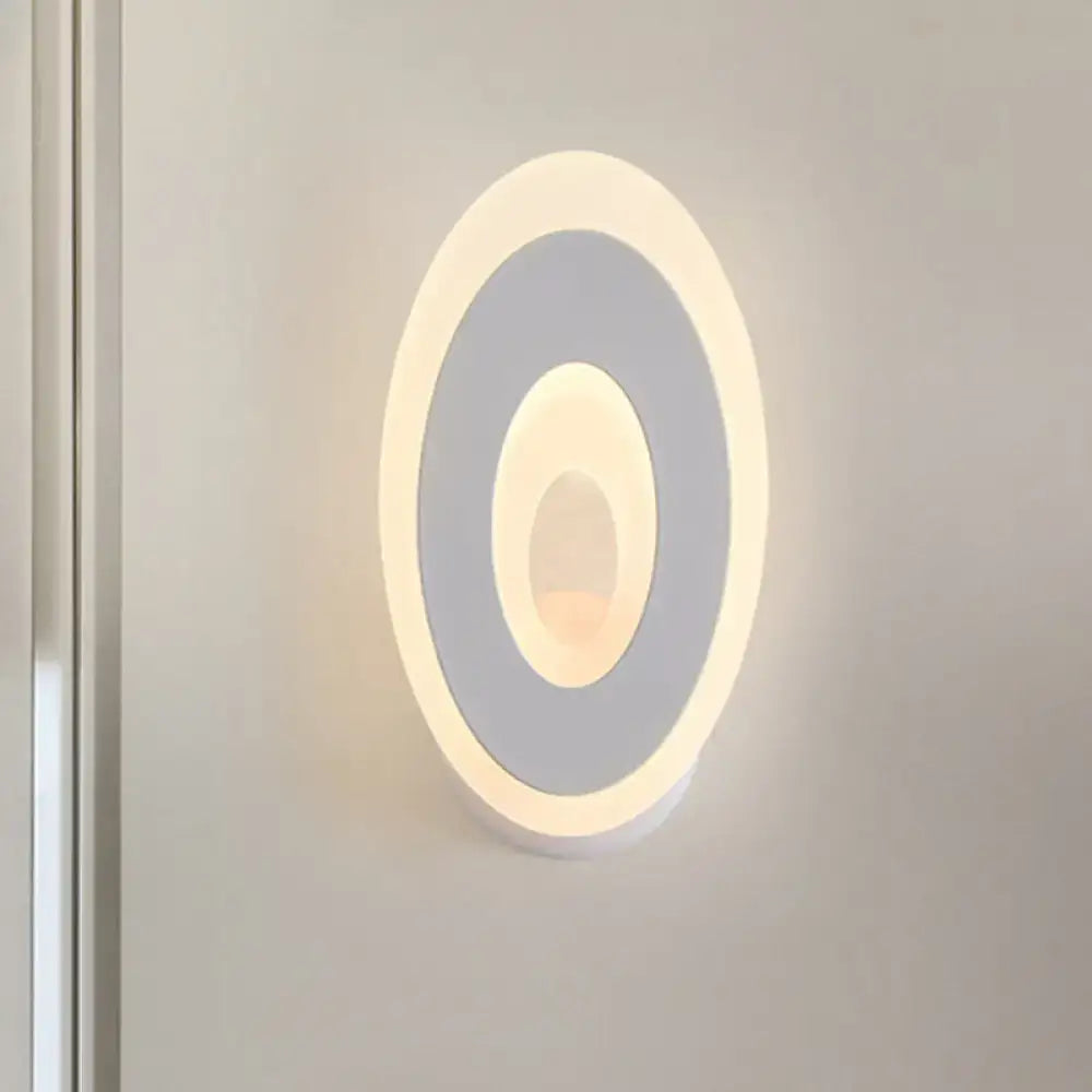 Modern black and cream oval direct wired electric wall lamp with concentric rings emitting warm ambient glow light type