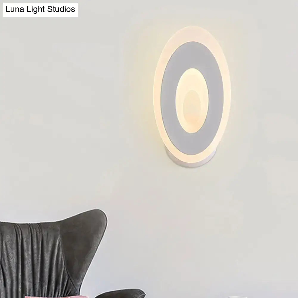 Modern black and cream oval direct wired electric wall lamp with concentric matte gray rings and warm white light type