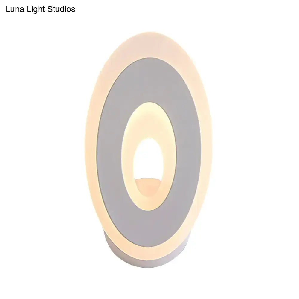 Modern black and cream oval direct wired electric wall lamp with concentric rings of matte gray and warm led lighting light type