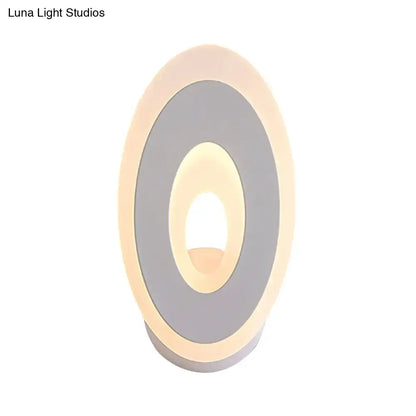 Modern black and cream oval direct wired electric wall lamp with concentric rings of matte gray and warm led lighting light type