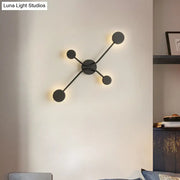 Modern black cross led wall lamp with four circular light fixtures in a symmetrical cross pattern for living room use