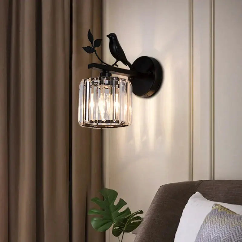 Modern black wrought iron wall lamp with decorbites crystal bird and cylindrical crystal shade for bedroom sconce decor