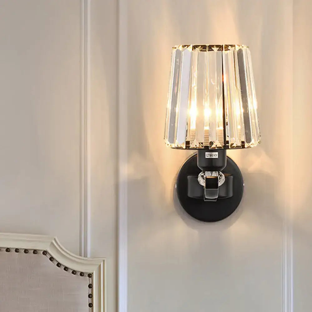A sleek black wall light with cascading clear crystal design prisms for elegant living room illumination