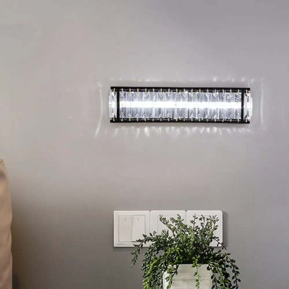 Modern black crystal rectangular sconce with clear crystal accents designed as a bedroom wall light fixture