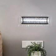 Modern black crystal rectangular sconce with clear crystal accents designed as a bedroom wall light fixture