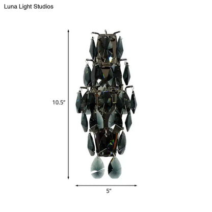 A sleek black crystal wall sconce with tiered teardrop crystals for modern living room gem fixture lighting