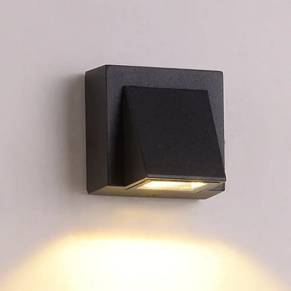 Modern black cube led wall sconce with matte finish and angled design emitting warm yellow light for 110v-120v use