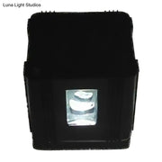 Modern black cubic led wall lamp featuring a rectangular projector with a clear lens housing three white curved light sources