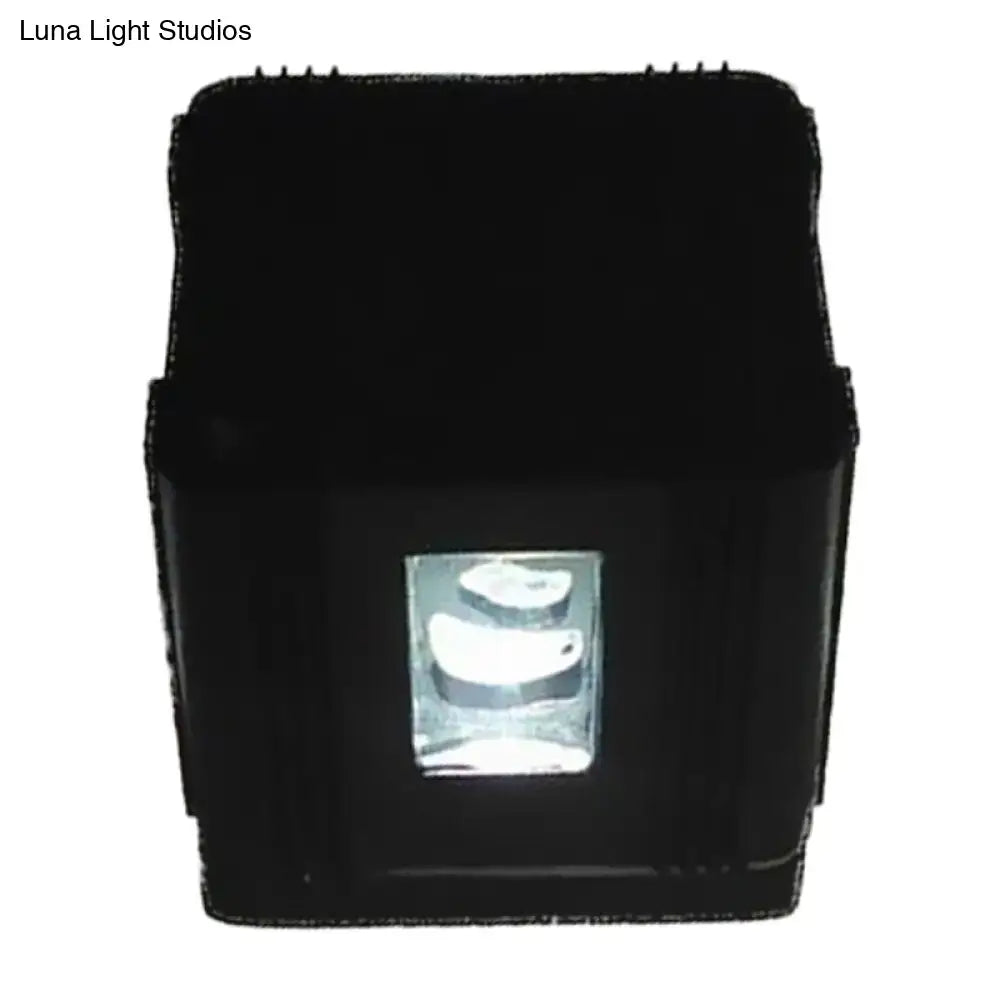 Modern black cubic led wall lamp featuring a rectangular projector with a clear lens housing three white curved light sources