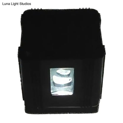 Modern black cubic led wall lamp featuring a rectangular projector with a clear lens housing three white curved light sources