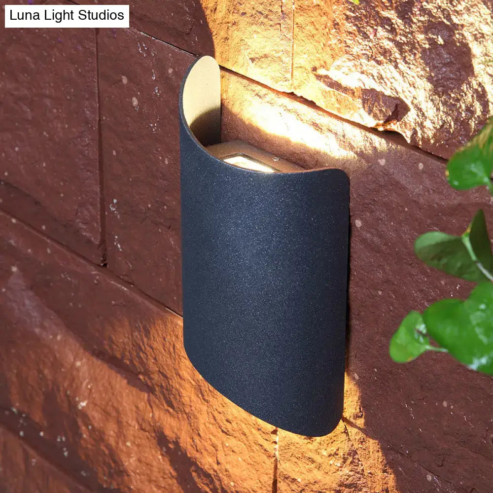 Modern black curved led wall lamp with matte finish for outdoor yard lighting mounted on a wall