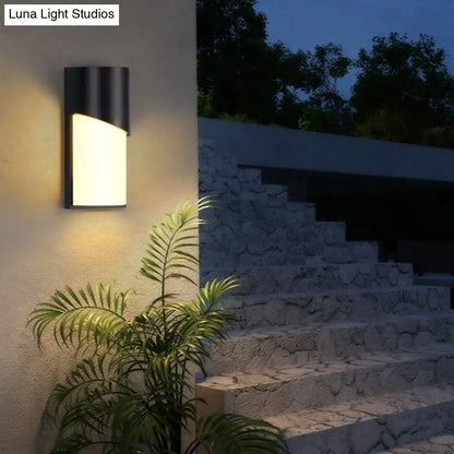 Modern black curved wall sconce with sleek design and warm white led light for outdoor patio use