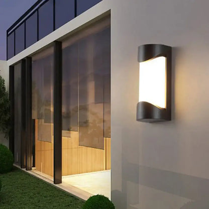 Modern black curved outdoor wall sconce with sleek design and warm white LED light for patio use