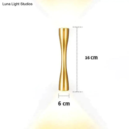Gold-colored brass wall sconce 16 cm tall with slender hourglass shape for modern black curved outdoor porch light