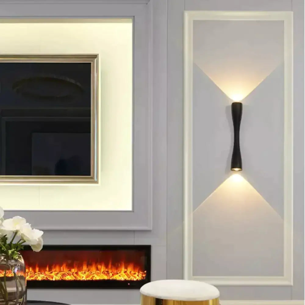 Modern black curved wall sconce outdoor waterproof porch light with sleek elongated design casting warm v-shaped light