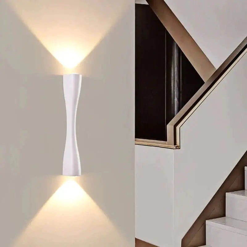 White sleek modern wall sconce with curved design casting warm light for outdoor porch waterproof use
