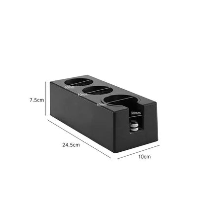 Modern black espresso tamper station with three circular slots and a small cylindrical component for decorbites espresso tamper