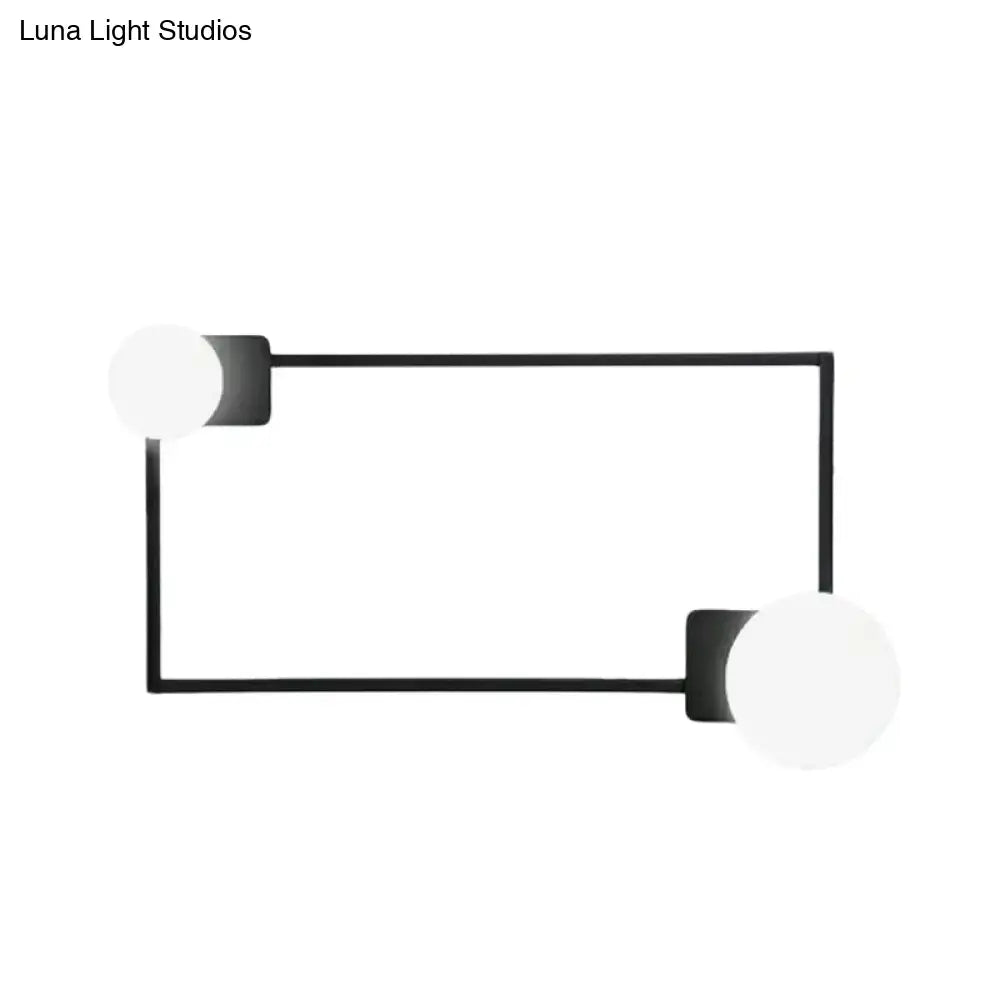 Minimalist modern wall sconce with black finish rectangular base and two white frosted glass globe shades for bedroom