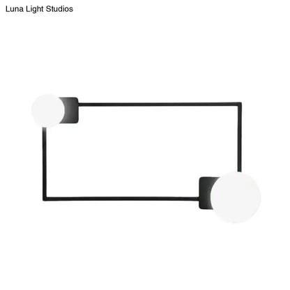 Minimalist modern wall sconce with black finish rectangular base and two white frosted glass globe shades for bedroom