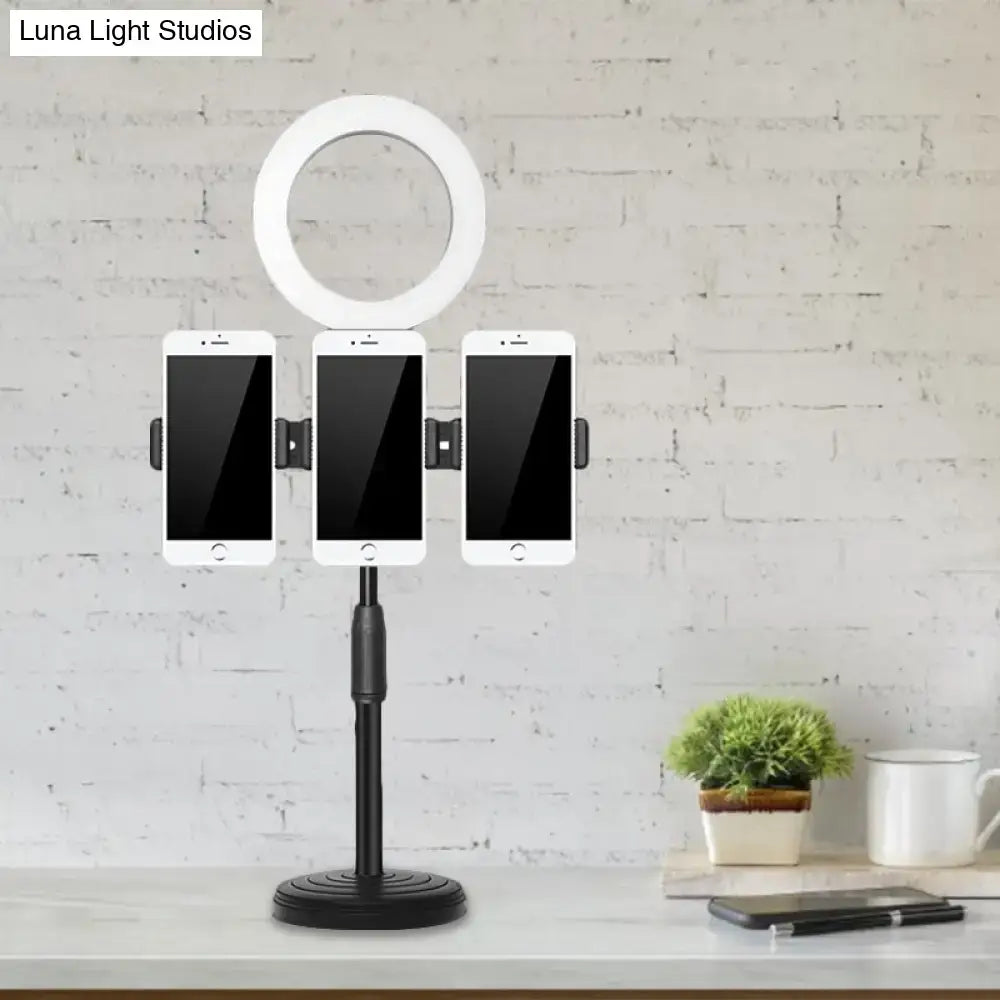 Modern vanity light with black finish and metal shade ring light featuring three phone holders on adjustable stand