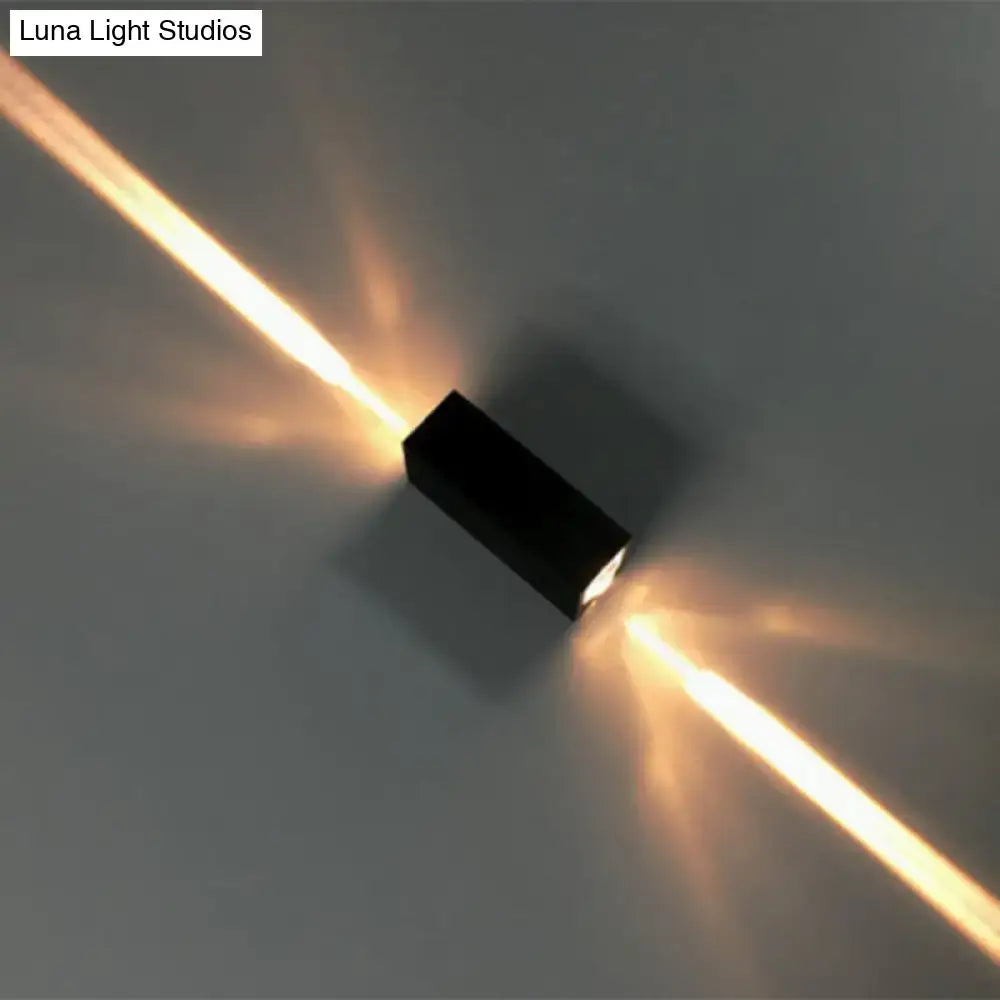 Modern black finish wall lamp with dual beam sconce design emitting warm directional light beams on wall