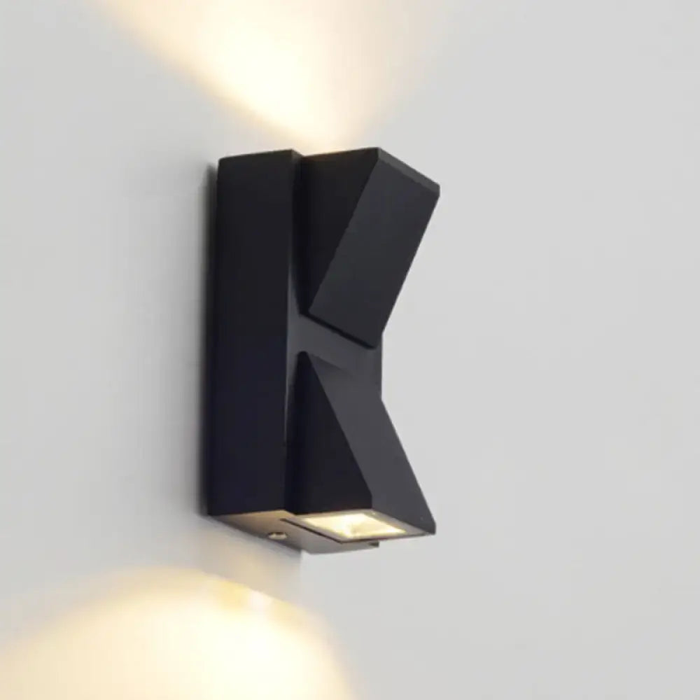 Modern black geometric led outdoor wall mount sconce with angular design emitting warm light for outdoor wall use