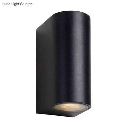 Modern black geometric led outdoor wall mount featuring a matte finish black cylindrical outdoor wall sconce with warm led light at the base