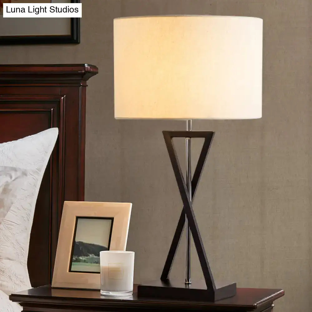 Decorbites simplicity fabric drum nightstand lamp with a dark x-shaped metal base and cream fabric shade for bedside use