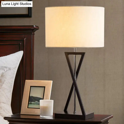Decorbites simplicity fabric drum nightstand lamp with a dark x-shaped metal base and cream fabric shade for bedside use