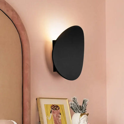 Modern black geometric wall lighting fixture featuring a sleek oval-shaped design ideal for bedroom wall lighting
