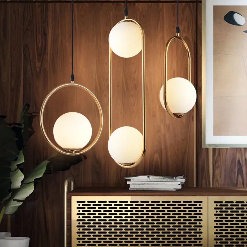 Three modern pendant lights with gold-toned metal frames and frosted glass spheres for decorbites glass ball pendant set
