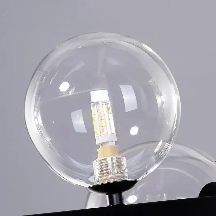 Clear glass bubble chandelier globe with modern led bulb featuring visible yellow leds and metallic base for dining room