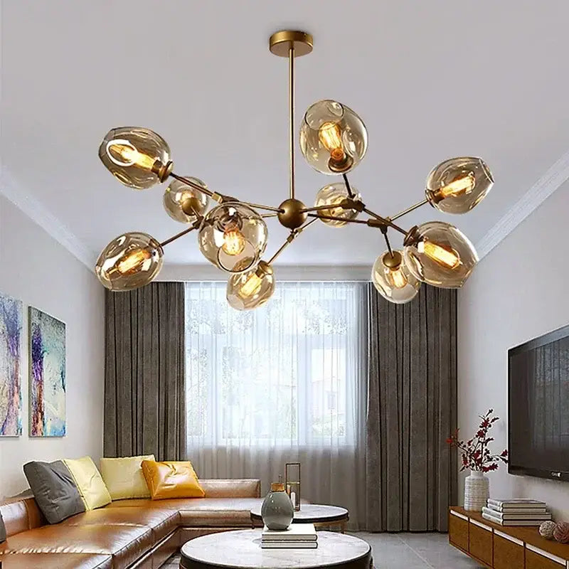 Modern black glass led chandelier pendant light featuring a gold-toned frame with amber glass globes and exposed bulbs