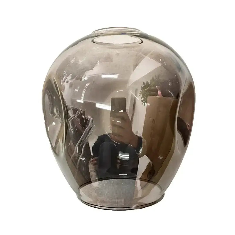 A sleek amber glass vase with a rounded body complements the modern black glass led chandelier pendant light