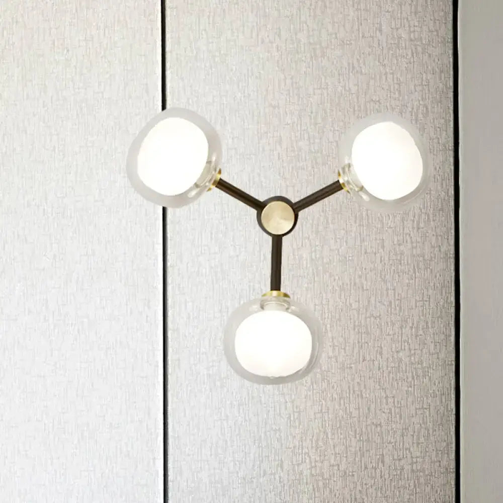 Modern black and gold three-light wall lamp with frosted glass shades for stylish bedroom lighting
