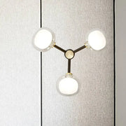 Modern black and gold three-light wall lamp with frosted glass shades for stylish bedroom lighting