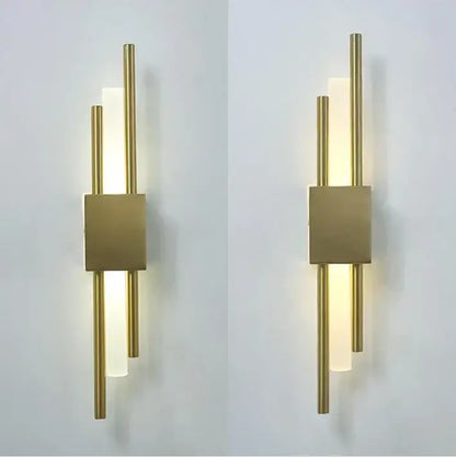 Modern black and gold acrylic pipe wall lamp with vertical gold acrylic pipe rods and frosted glass panels emitting warm light