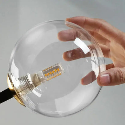 Modern black and gold branching bubbles chandelier featuring a clear glass globe lamp with a gold-toned metal base and led bulb