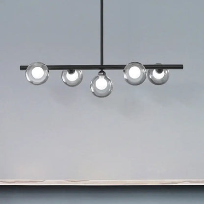Modern black metal ceiling light with five bubble clear glass globe bulbs for a clear glass island dining room