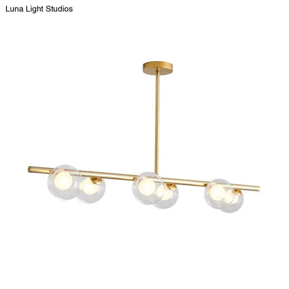 Modern black and gold ceiling light with gold-toned frame and bubble clear glass globe shades for dining room island